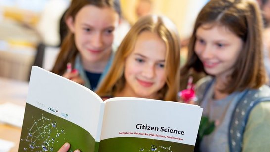 Young-Science-Kongress 2022 Drei Schülerinnen werfen einen Blick in die Citizen-Science-Broschüre